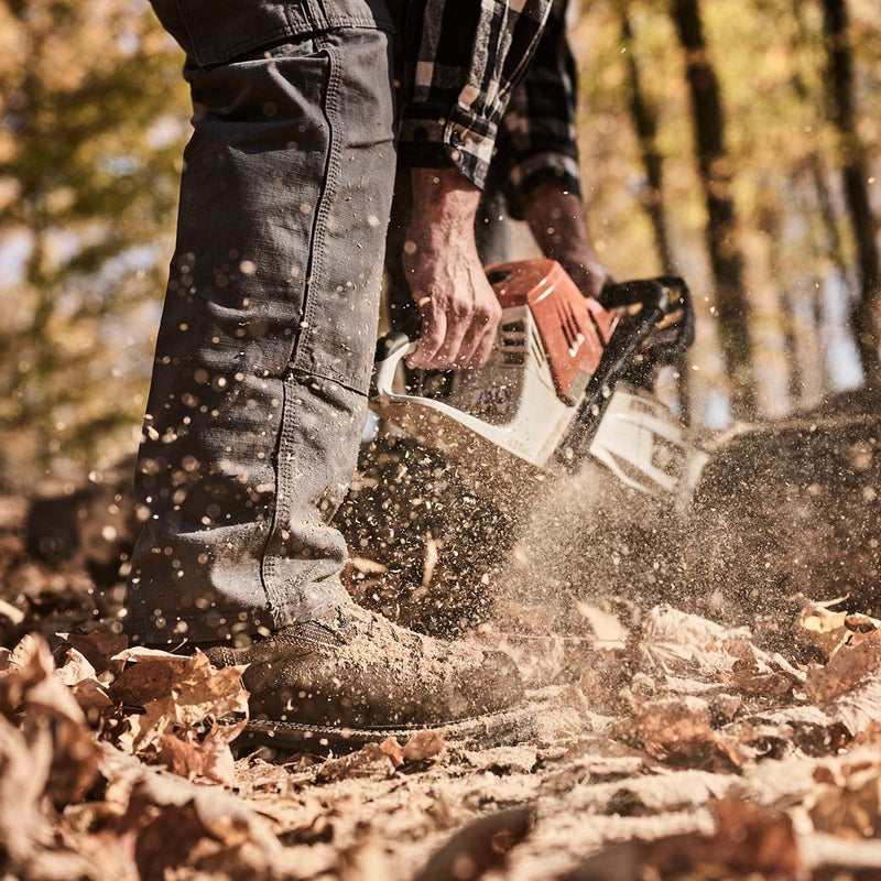 Person using a chainsaw in a forest setting