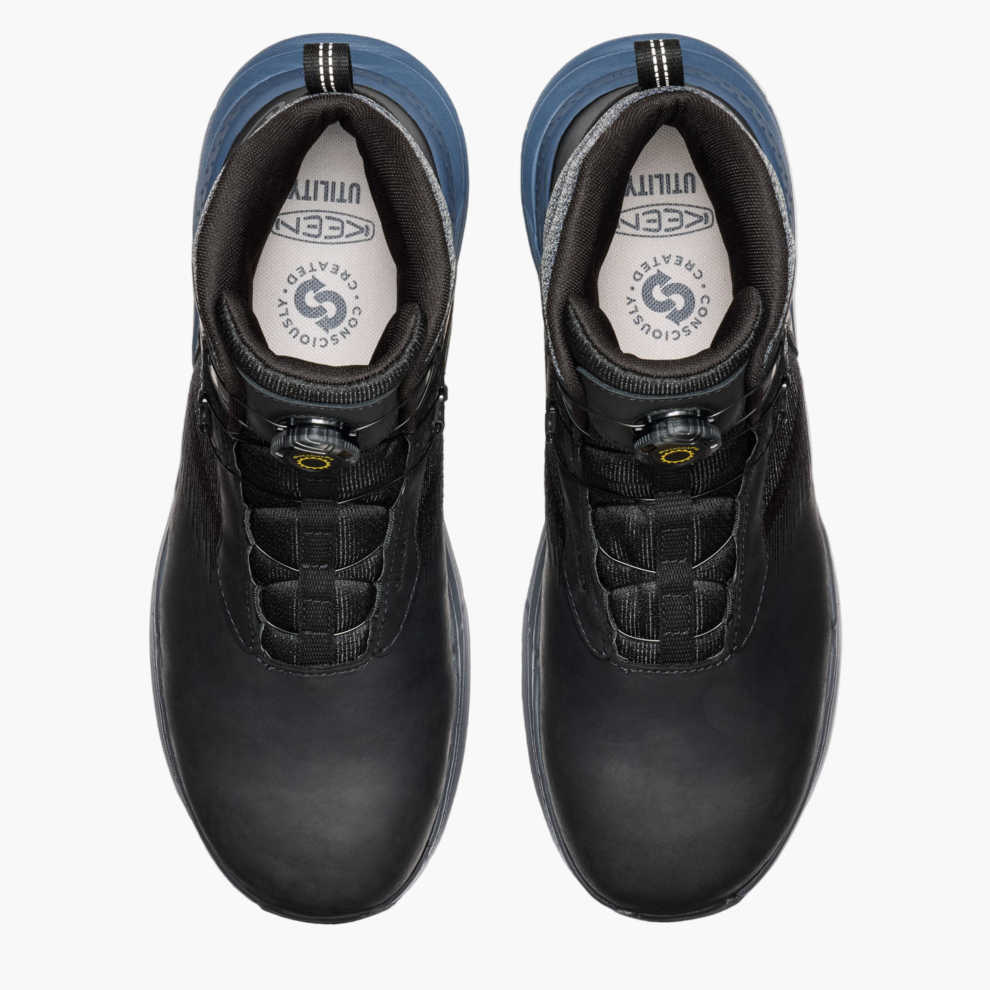 Black work boots with blue soles on a white background